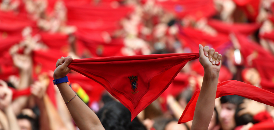 Cientos de personas festejan en la Plaza del Castillo de Pamplona, con sus pañuelos rojos alzados, el inicio de las fiestas de San Fermín