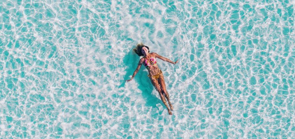 Mujer bañándose en la playa - Unsplash