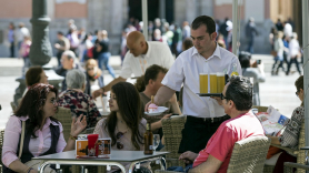 Un camarero sirve bebidas en una terraza en Valencia