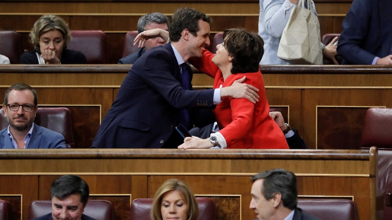 Soraya Sáenz de Santamaría (d), saluda a Pablo Casado (i), durante un pleno, debajo María Dolores de Cospedal. EFE/Archivo