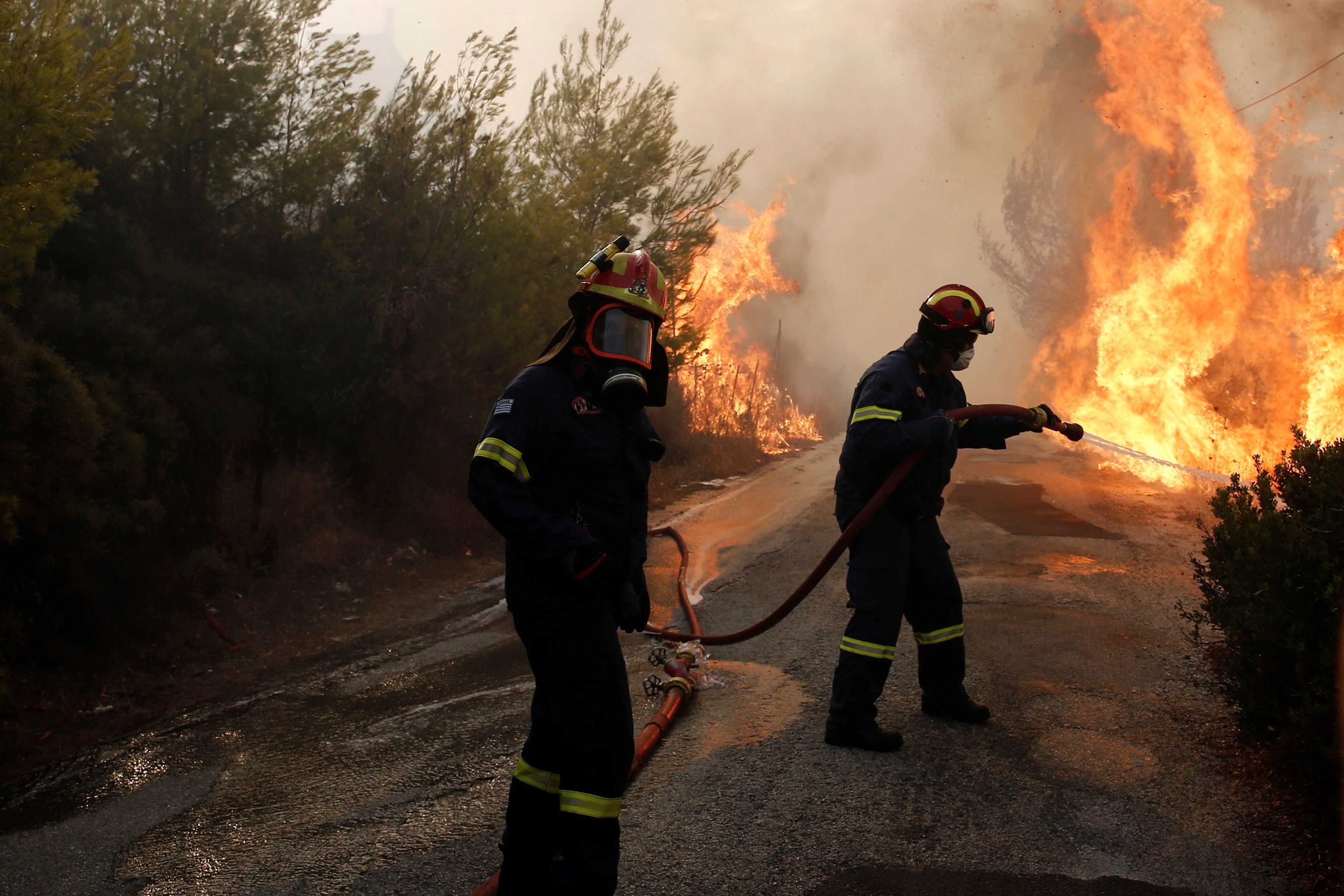 Bomberos tratan de extinguir un incendio en Penteli, al norte de Atenas (Grecia), hoy. EFE