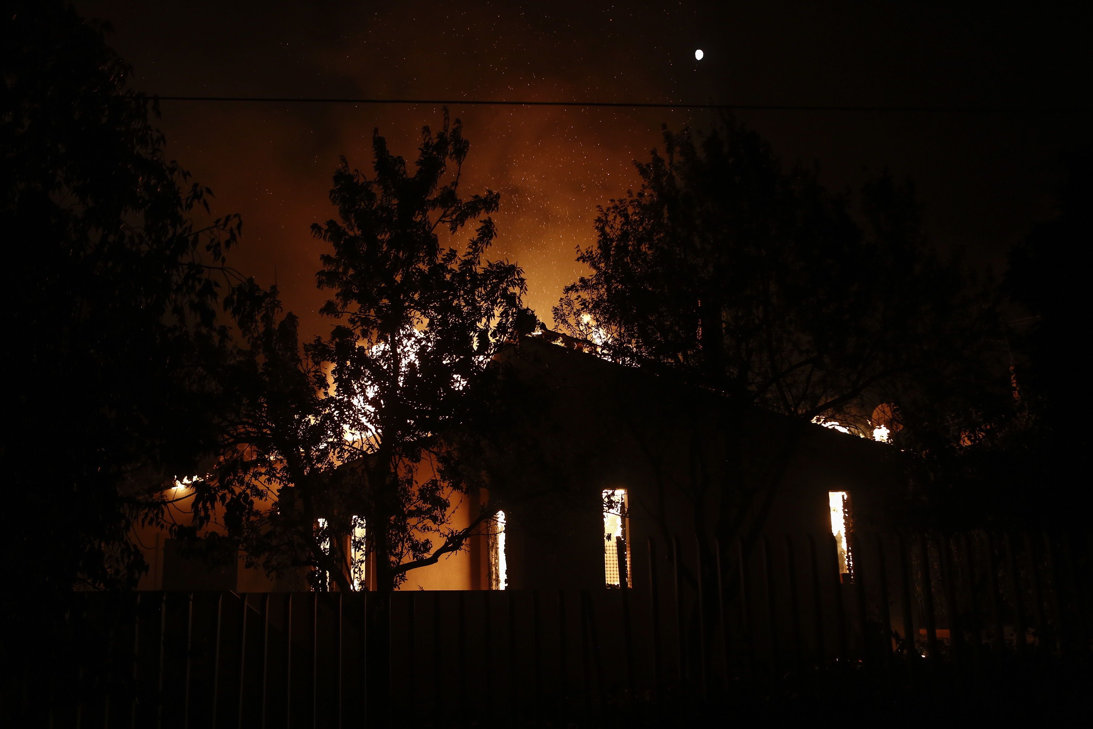 Una vivienda arde hoy en llamas durante un incendio forestal en Mati, un suburbio al noreste de Atenas (Grecia). Después del incendio forestal en Kineta, un segundo incendio estalló en la montaña Penteli. EFE