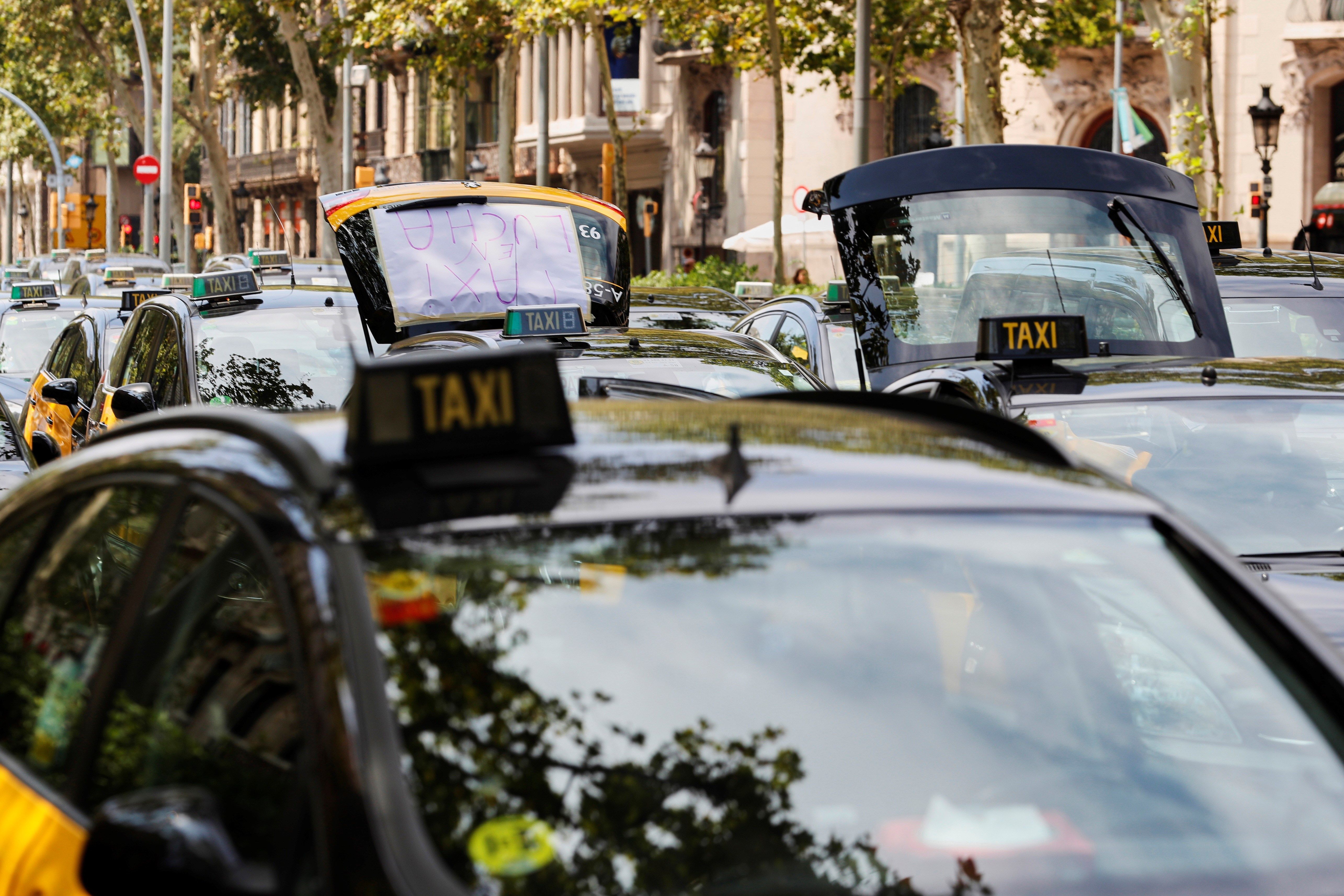 Taxistas en huelga ocupan ayer la Gran Vía de Barcelona en protesta por la concesión de licencias a vehículos de transporte con conductor (VTC). EFE