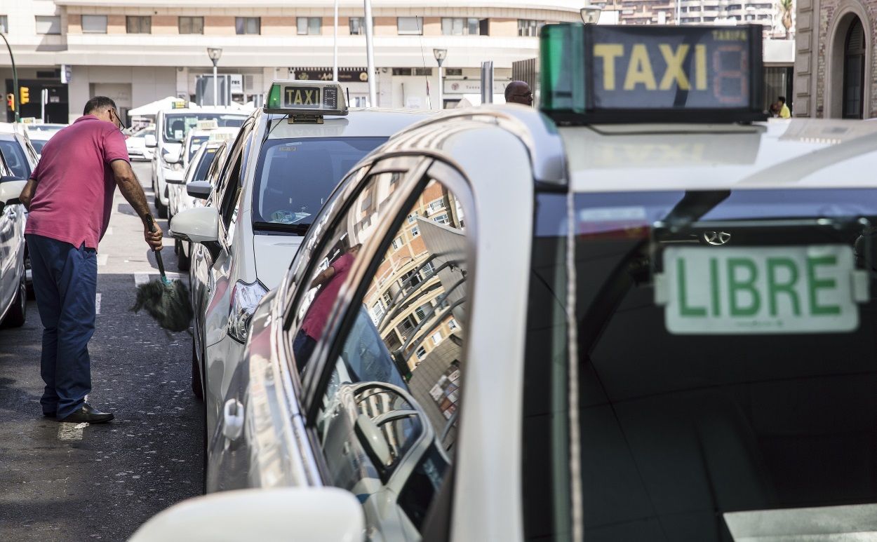 Un taxista limpia su coche en la parada de la estación María Zambrano de Málaga