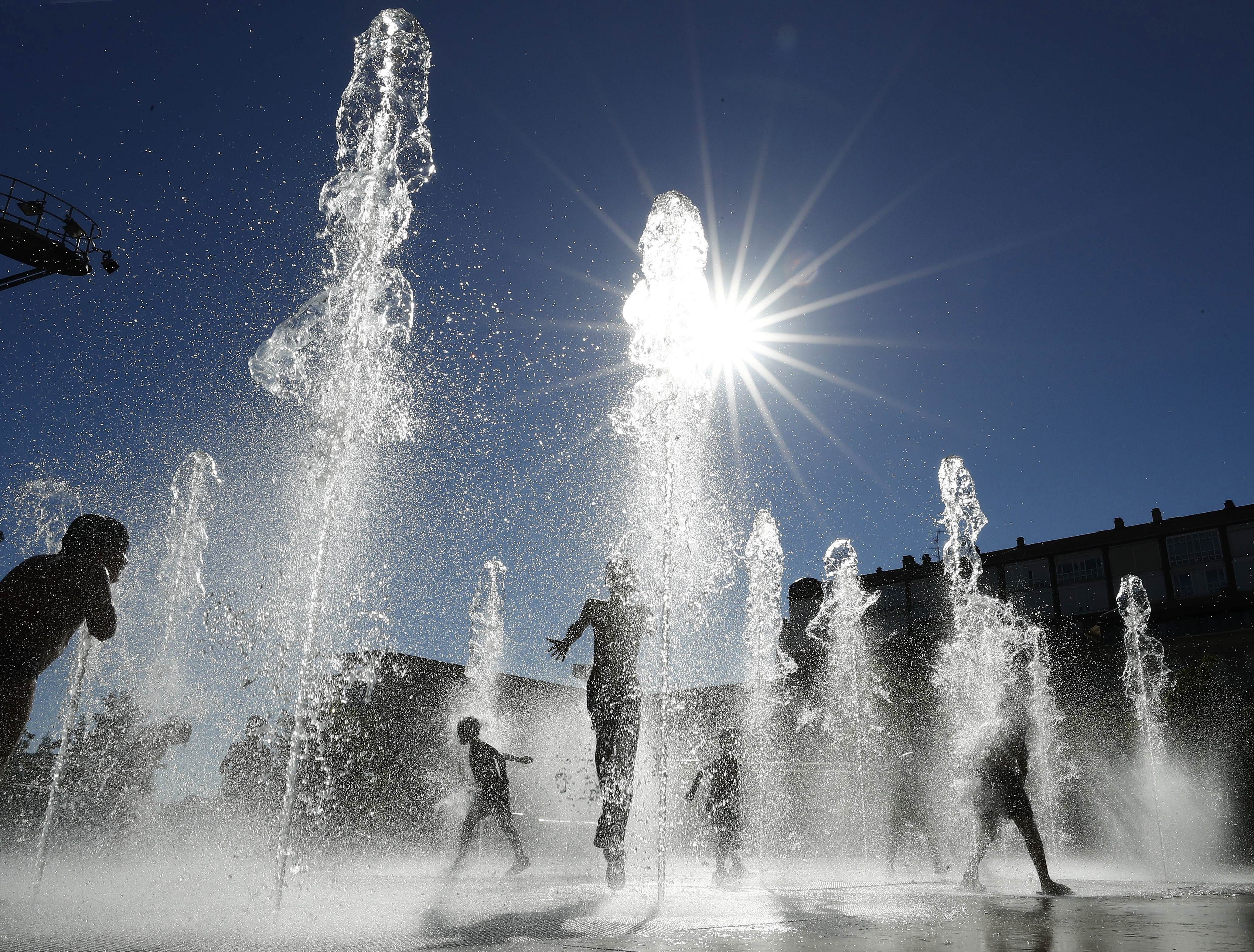 Un grupo de niños se refresca en una fuente de Pamplona - EFE