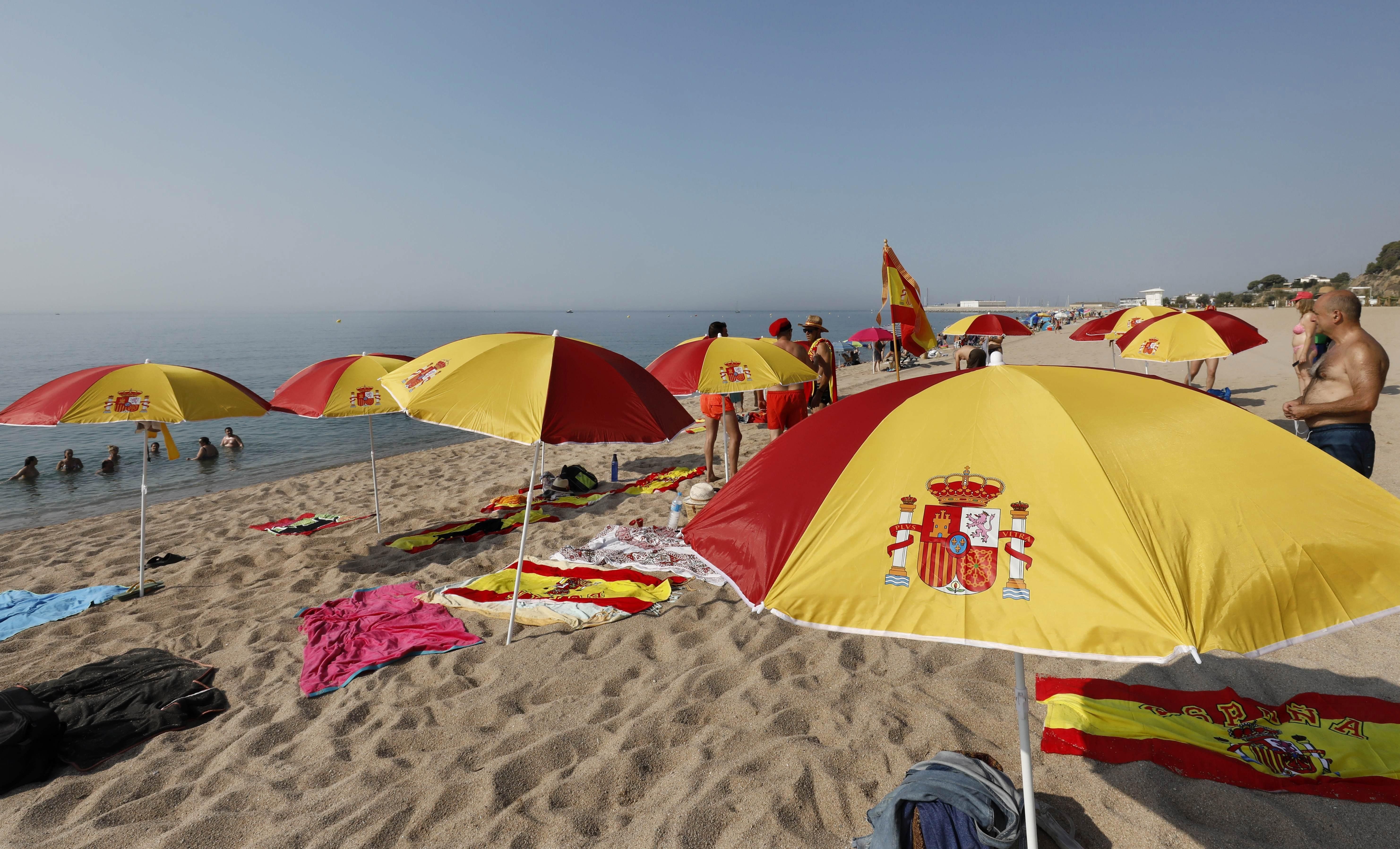 Sombrillas con la bandera de España en la playa de Arenys de Mar