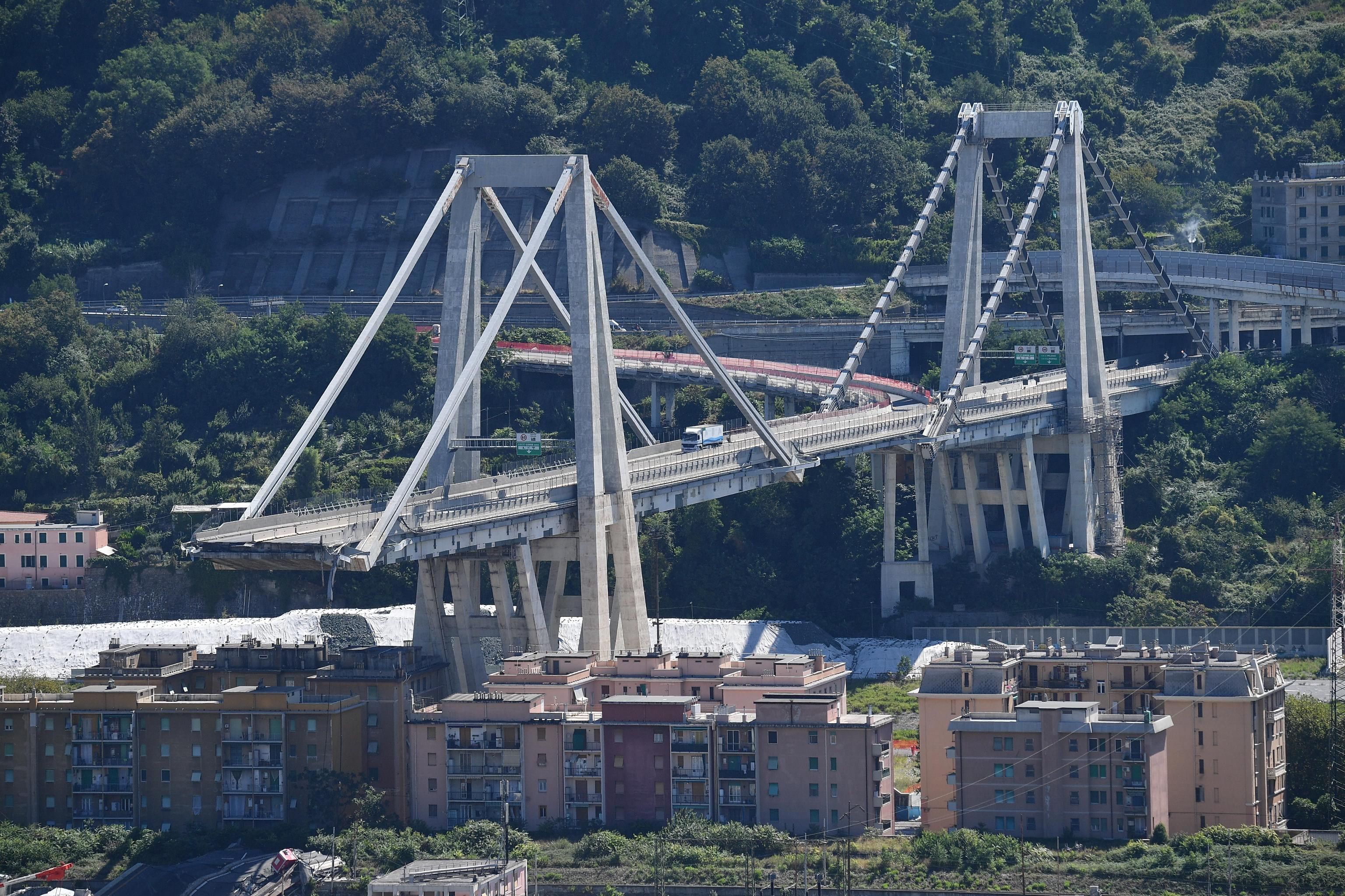 Vehículos permanecen sobre una sección de un puente que continúa en pie tras el desplome de un tramo el martes en Génova (Italia). EFE