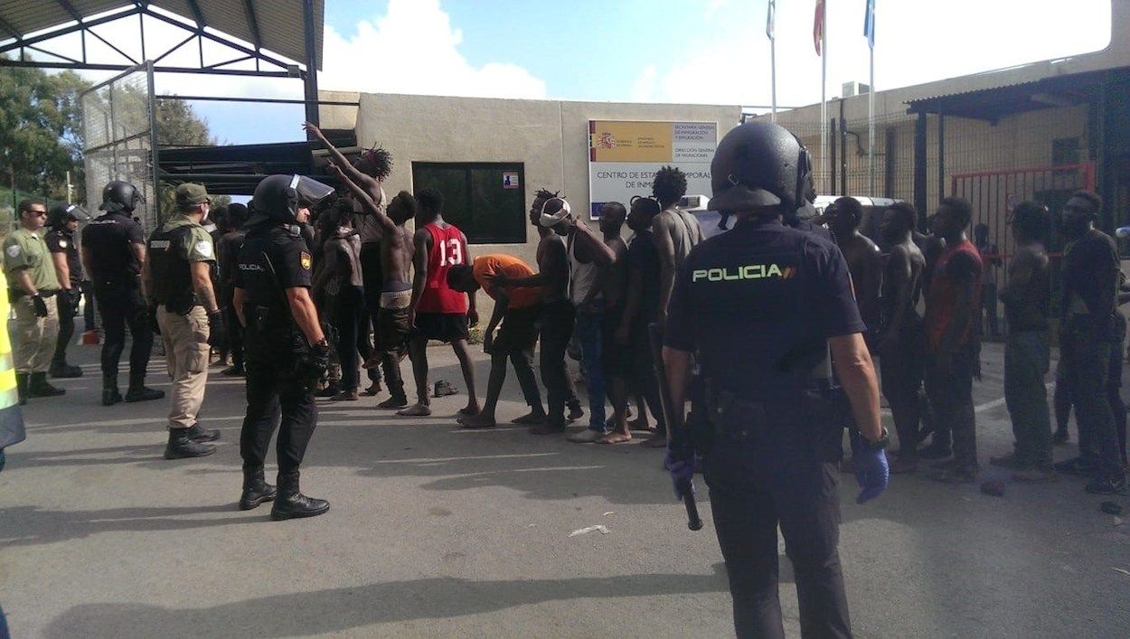 Policías custodian a los inmigrantes que han saltado la valla de Ceuta. EFE