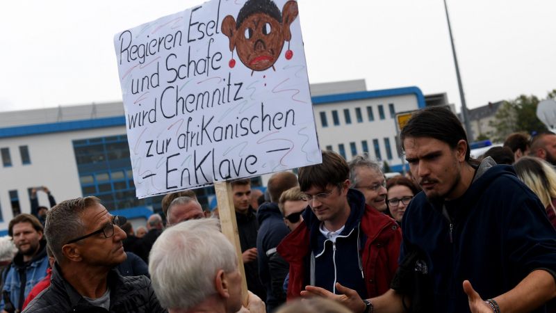 Un manifestante sostiene una pancarta en la que se lee " Si mandan burros y ovejas, Chemnitz se convierte en un enclave africano" Un manifestante sostiene una pancarta en la que se lee " Si mandan burros y ovejas, Chemnitz se convierte en un enclave africano"