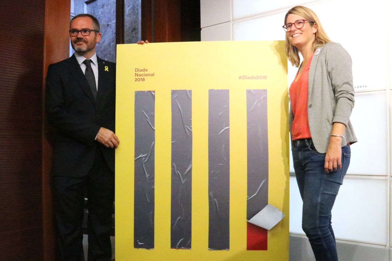 La portavoz del Govern, Elsa Artadi, y el vicepresidente primero del Parlament, Josep Costa, junto a l cartel de la Diada 2018