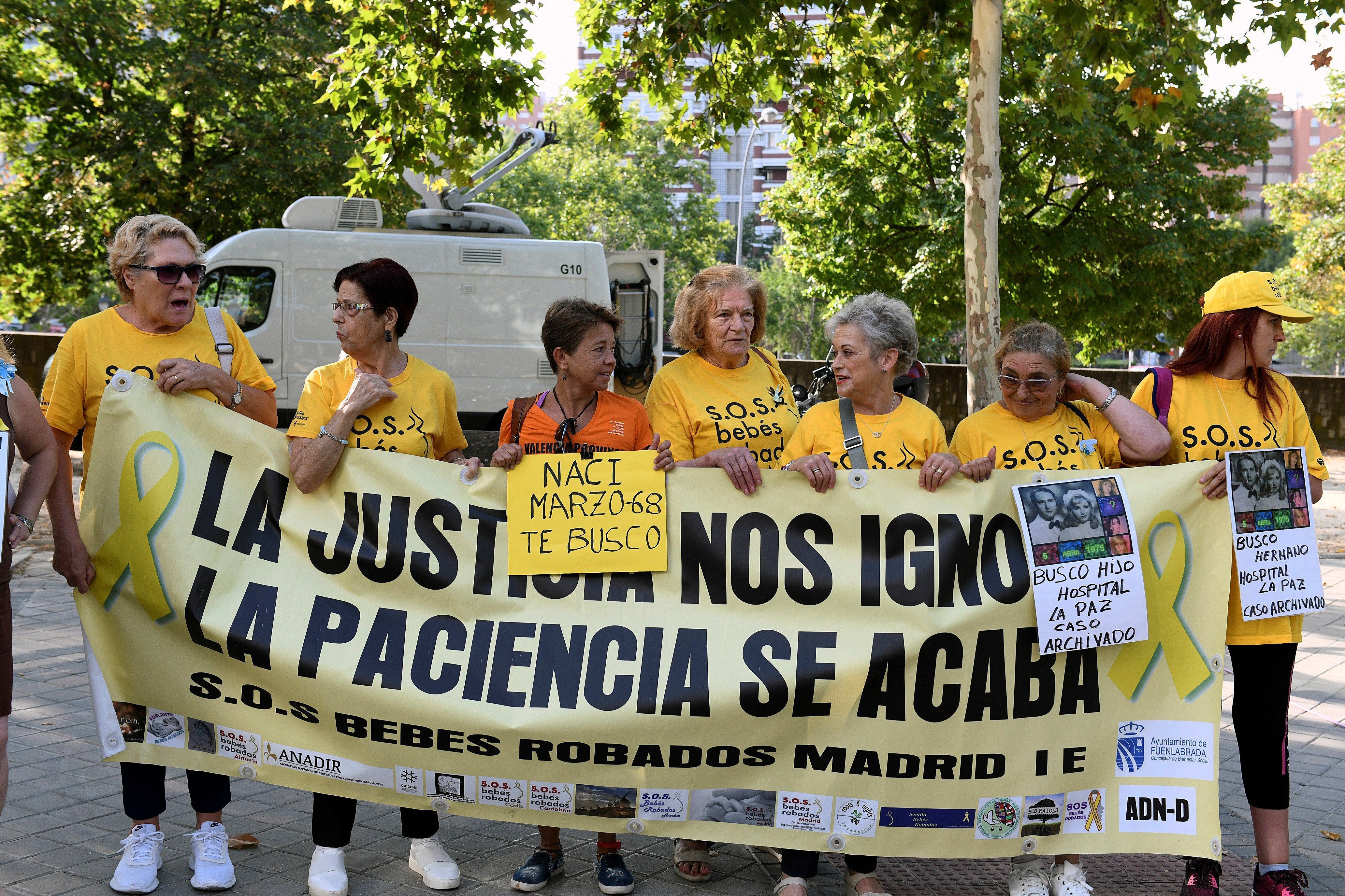 Miembros de la 'Asociación S.O.S. Bebés robados' con una pancarta a las puertas de la Audiencia Provincial de Madrid.