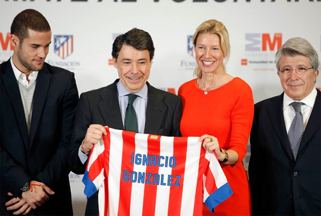 El presidente de la Comunidad de Madrid, Ignacio González, posa con una camiseta del Atlético de Madrid con su nombre, regalada por Enrique Cerezo
