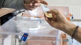 Un votante muestra su DNI en una mesa electoral.