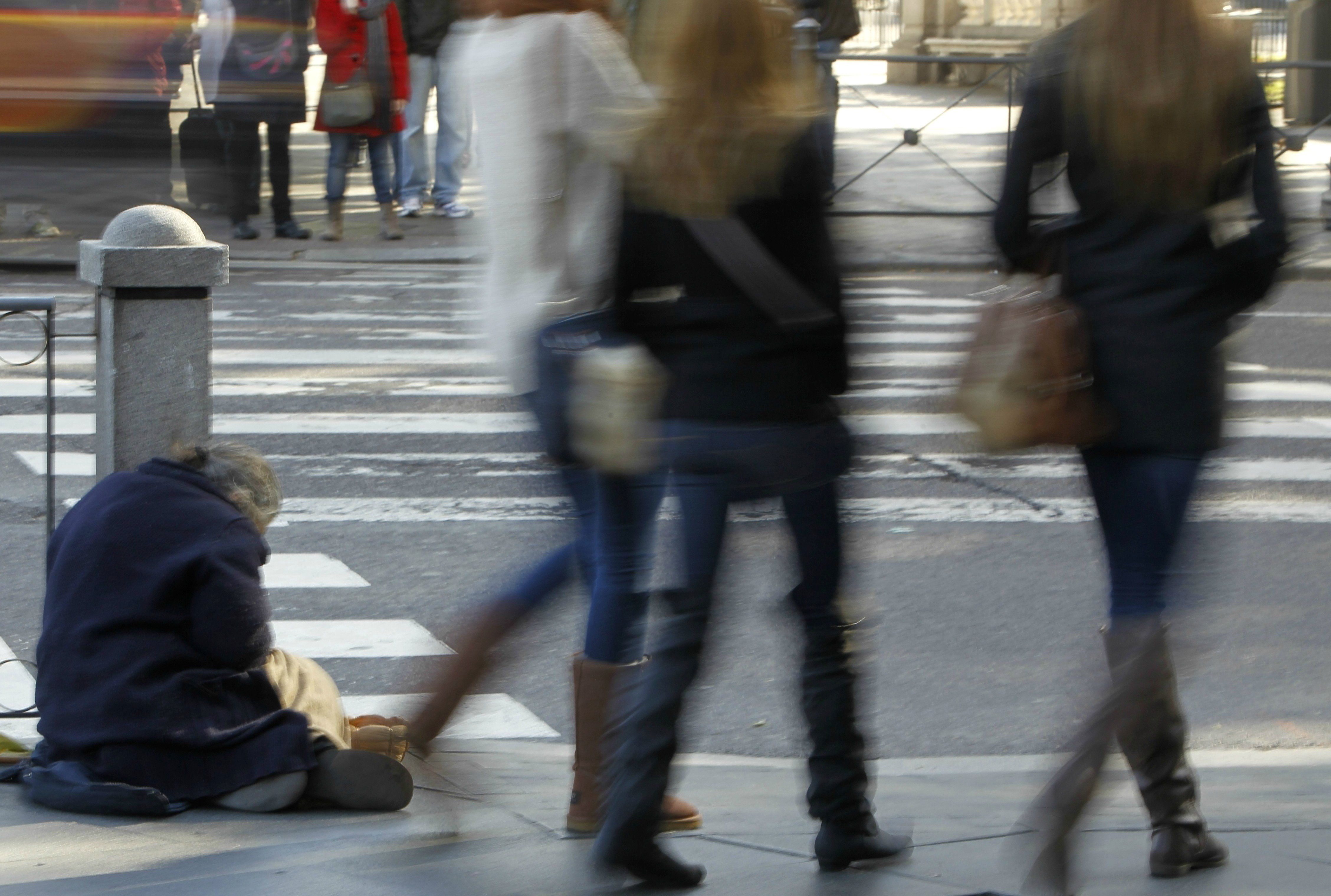 Un mendigo pide limosna en la Plaza de Cibeles de la capital española