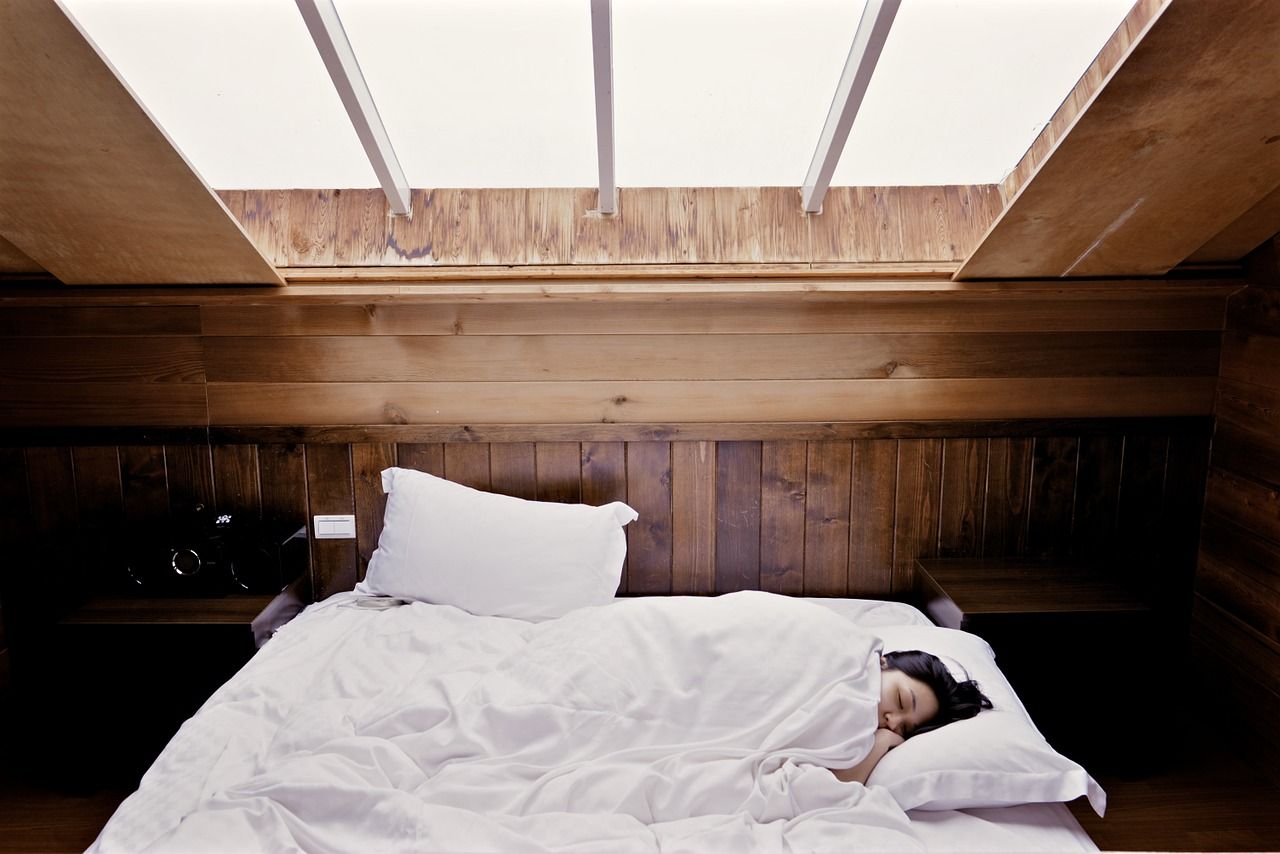 Una mujer descansa en su cama. Pixabay