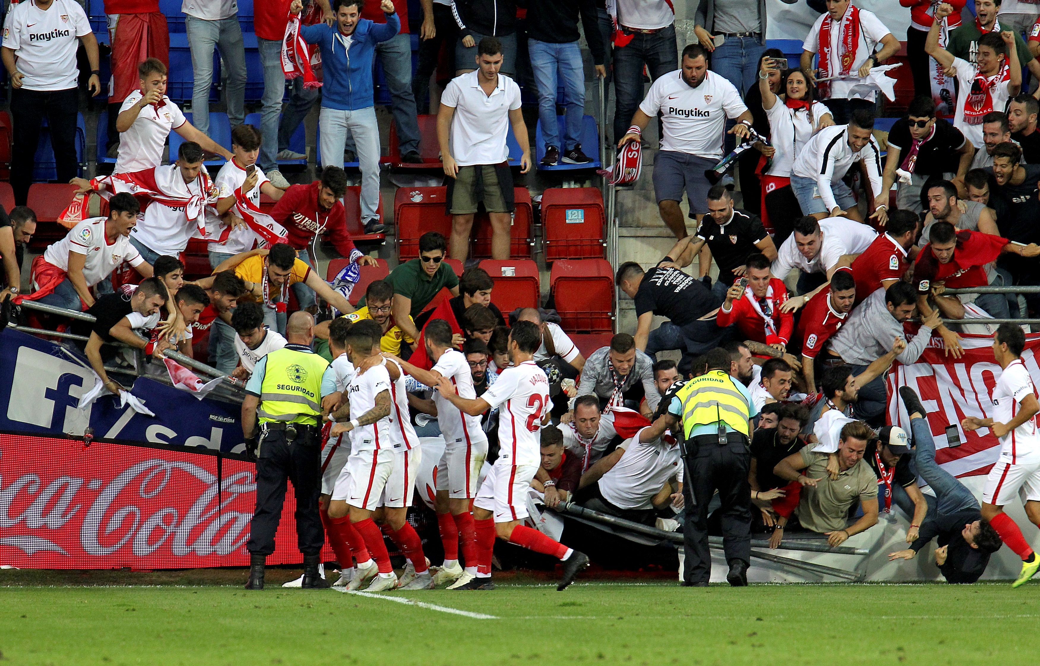 Aficionados del Sevilla caen tras ceder una de las vallas en la celebración del segundo gol del equipo andaluz