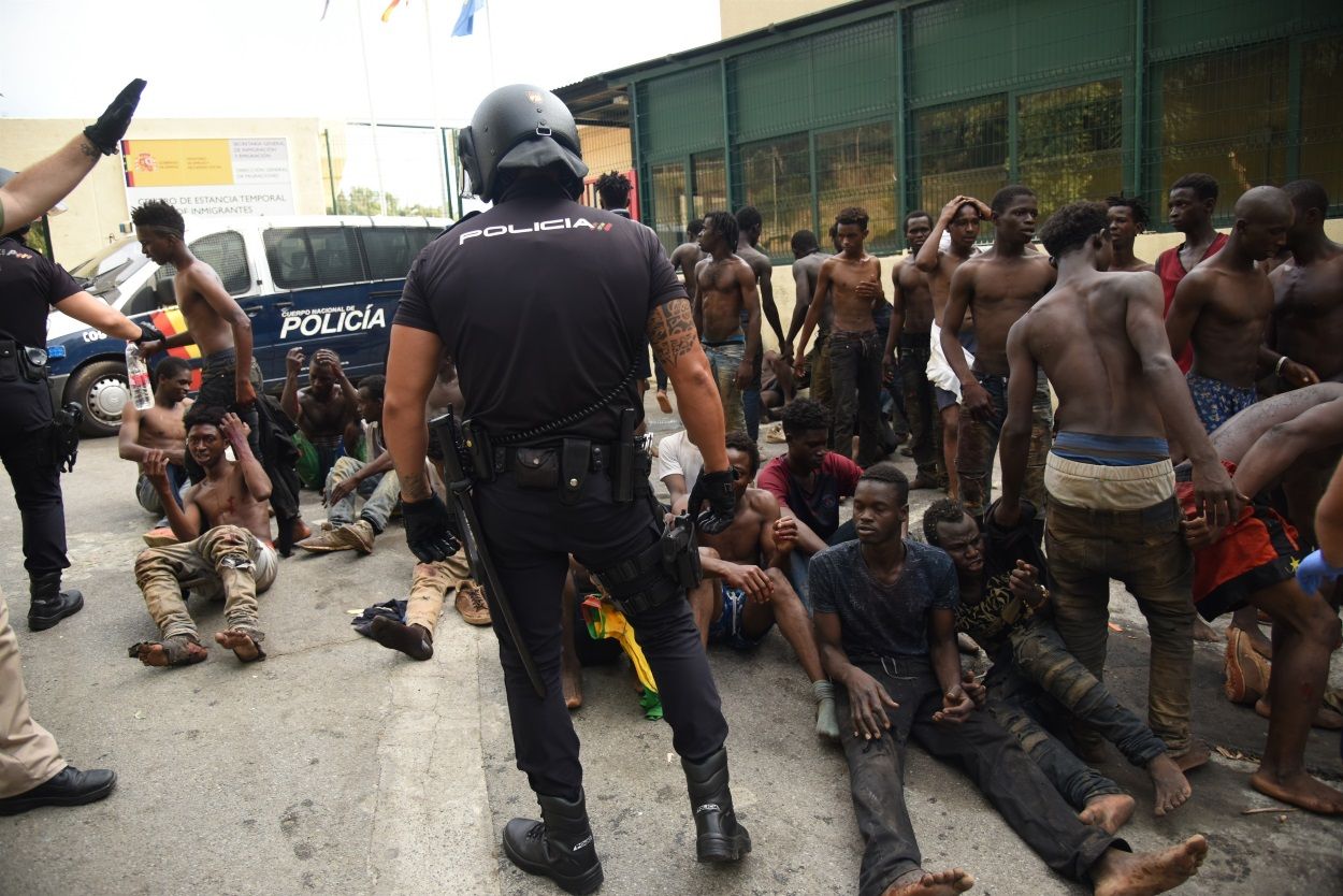 Agentes de la Policía vigilando a inmigrantes en Ceuta. EUROPA PRESS