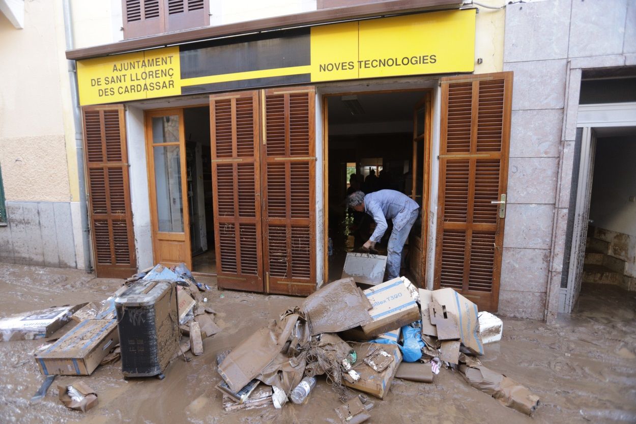 Un hombre trabaja a las puertas de un local en Sant Llorenç (Mallorca) tras las intensas lluvias. EP