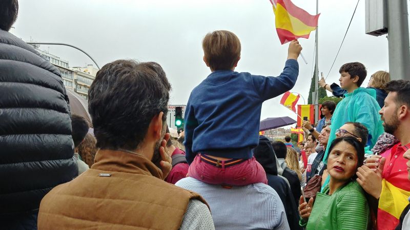 Niño con cinturón y banderola de España en el 12-O. 