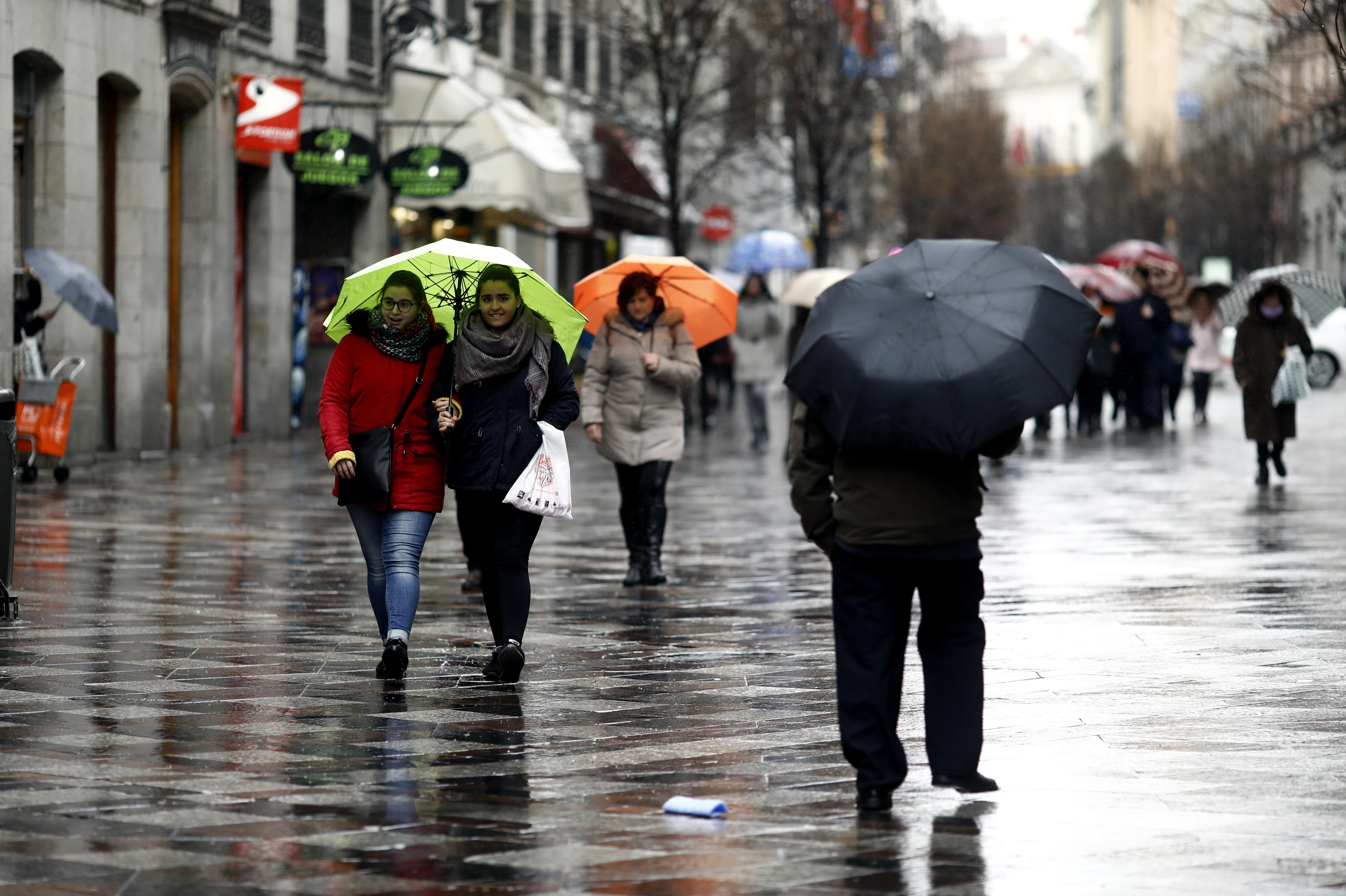 Transeúntes lidian con el frío y la lluvia en una imagen de archivo - Oscar del Pozo / Europa Press