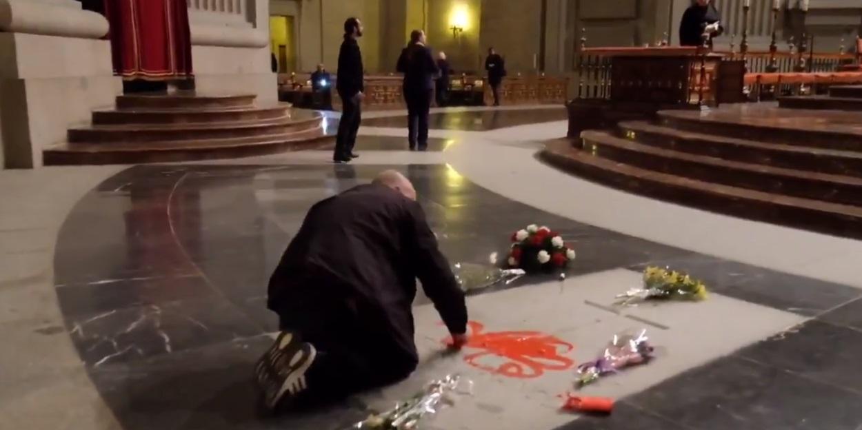 Un hombre pinta la lápida de Franco con pintura roja