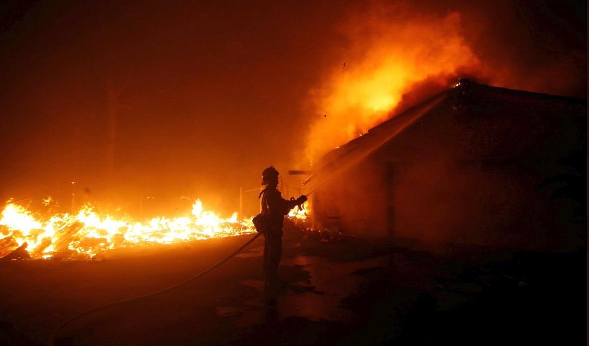 Un bombero intenta apagar las llamas que consumen una vivienda en California. Europa Press