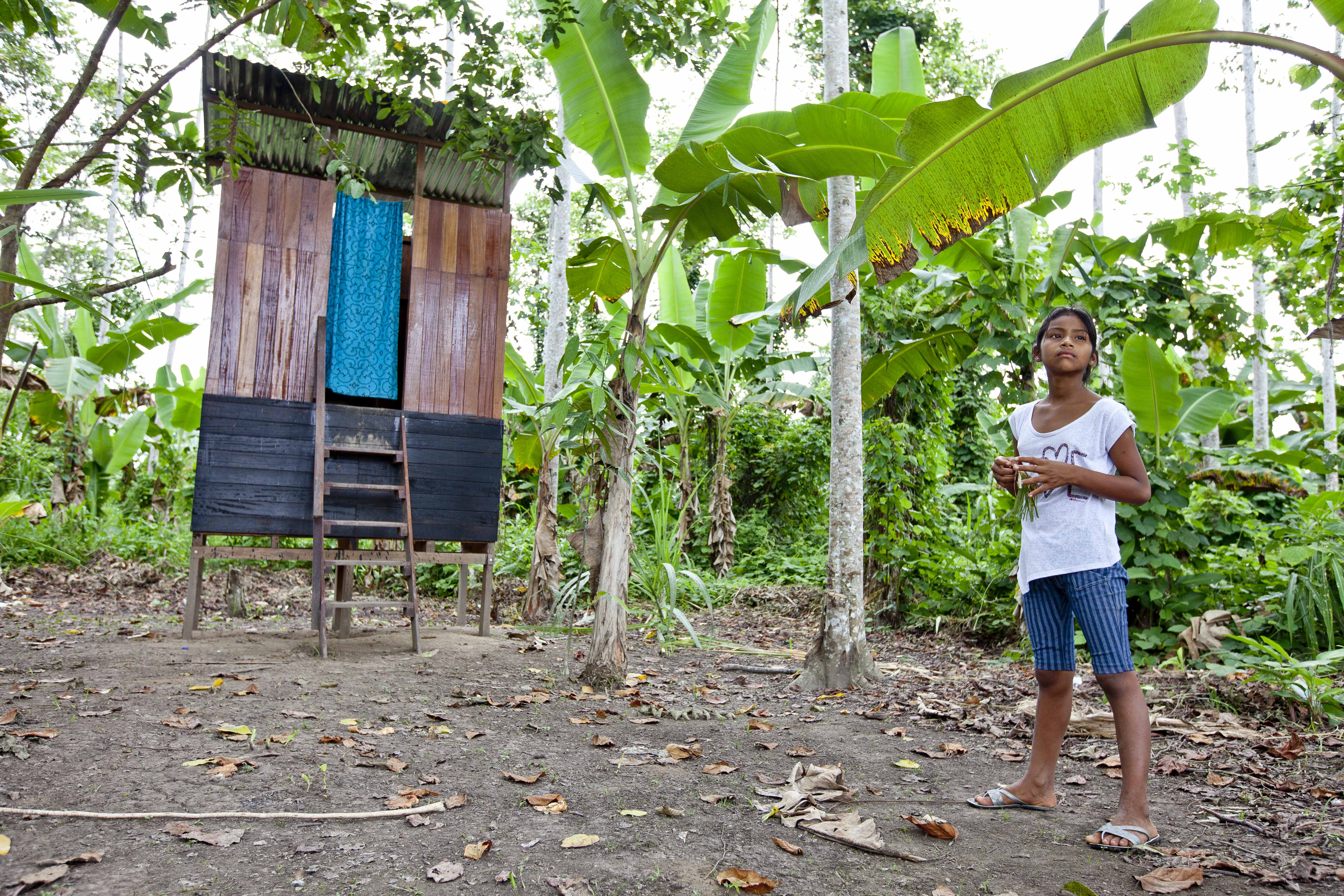 Una niña peruana junto a una de las letrinas ecológicas instaladas en la Amazonía