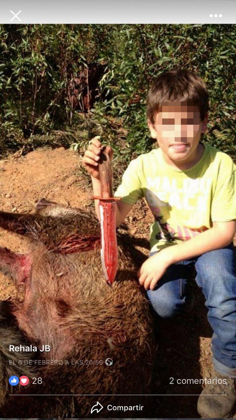 Un menor de edad sujeta un puñal sobre una presa de caza. PACMA