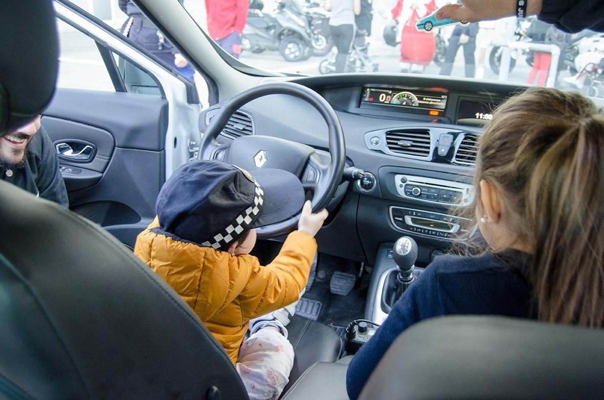 Un niño juega en un coche la policía municipal de Huelva