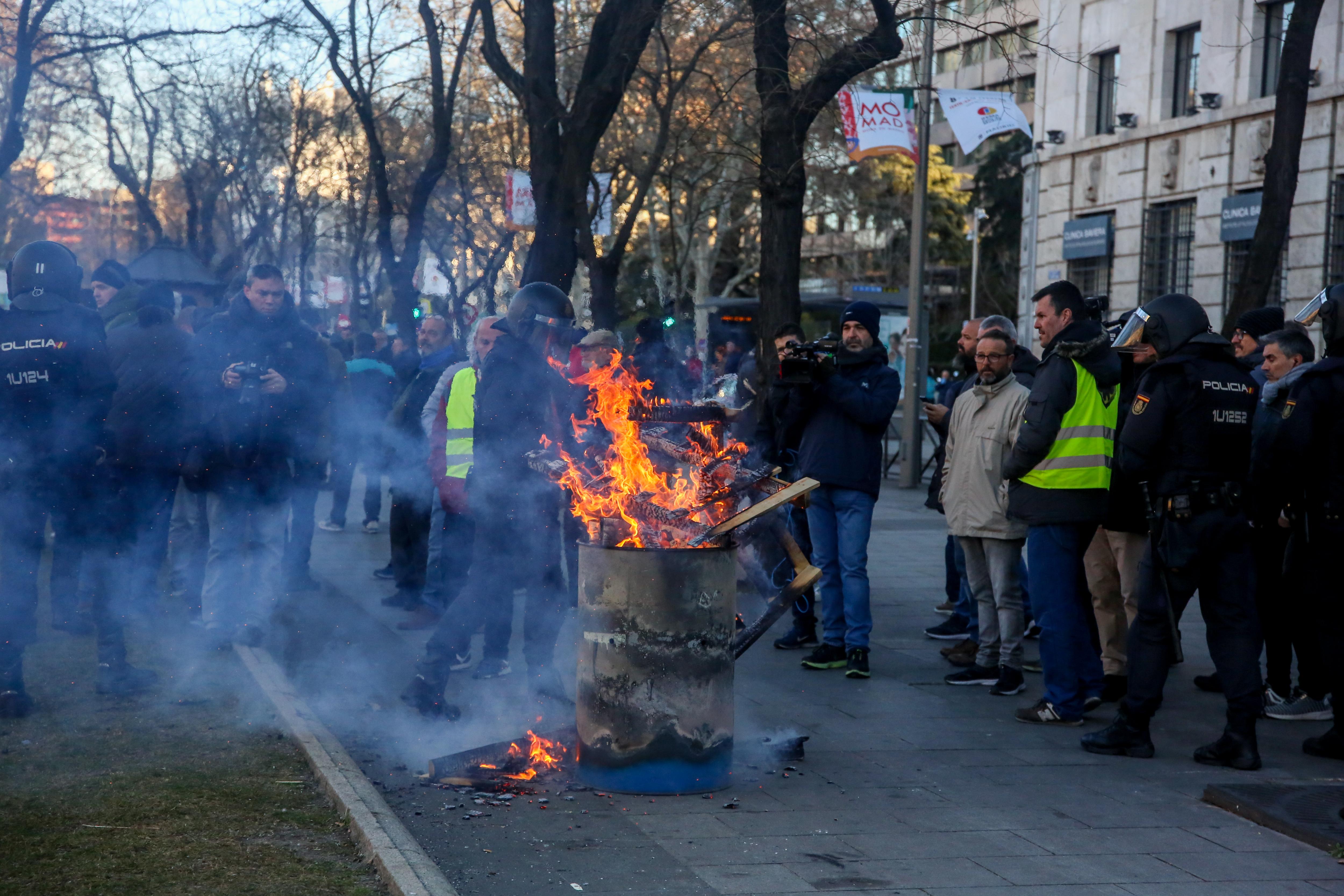 El miembro de la plataforma Caracol y portavoz del comité de huelga de taxis de Madrid Saúl Crespo (a la derecha con chaleco amarillo) al lado de una hoguera