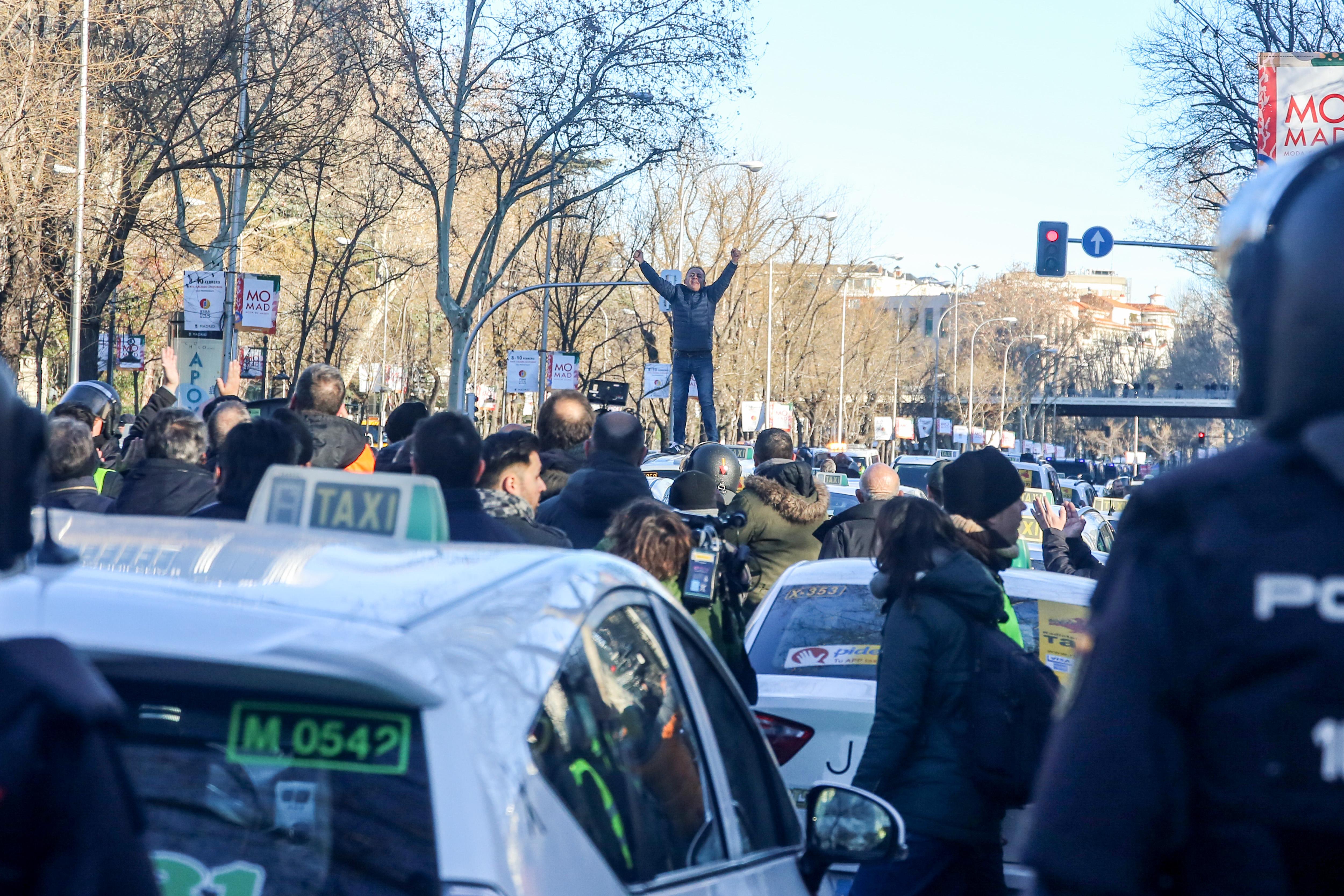 Un taxista se sube a un coche para dar una charla durante una concentración de taxistas en el Paseo de la Castellana de Madrid el 28 de enero - Ricardo Rubio Europa Press