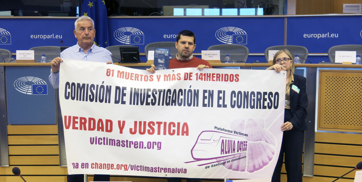 El presidente de la Asociación Plataforma de Víctimas del Alvia 04155, Jesús Domínguez, sostiene una pancarta junto a más familiares de las víctimas en la Comisión de Peticiones del Parlamento Europeo, donde pidieron una nueva investigación independiente 