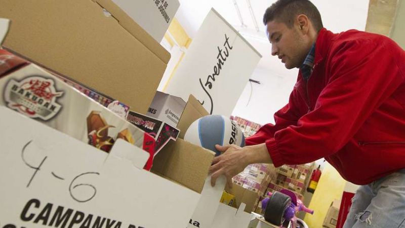 Varios voluntarios empaquetan juguetes durante la campaña de la Cruz Roja Española