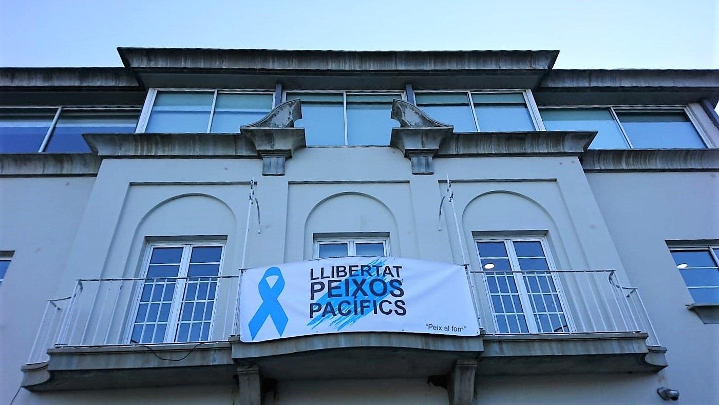 Pancarta con el lema Llibertat peixos pacífics en el ayuntamiento de Port de la Selva