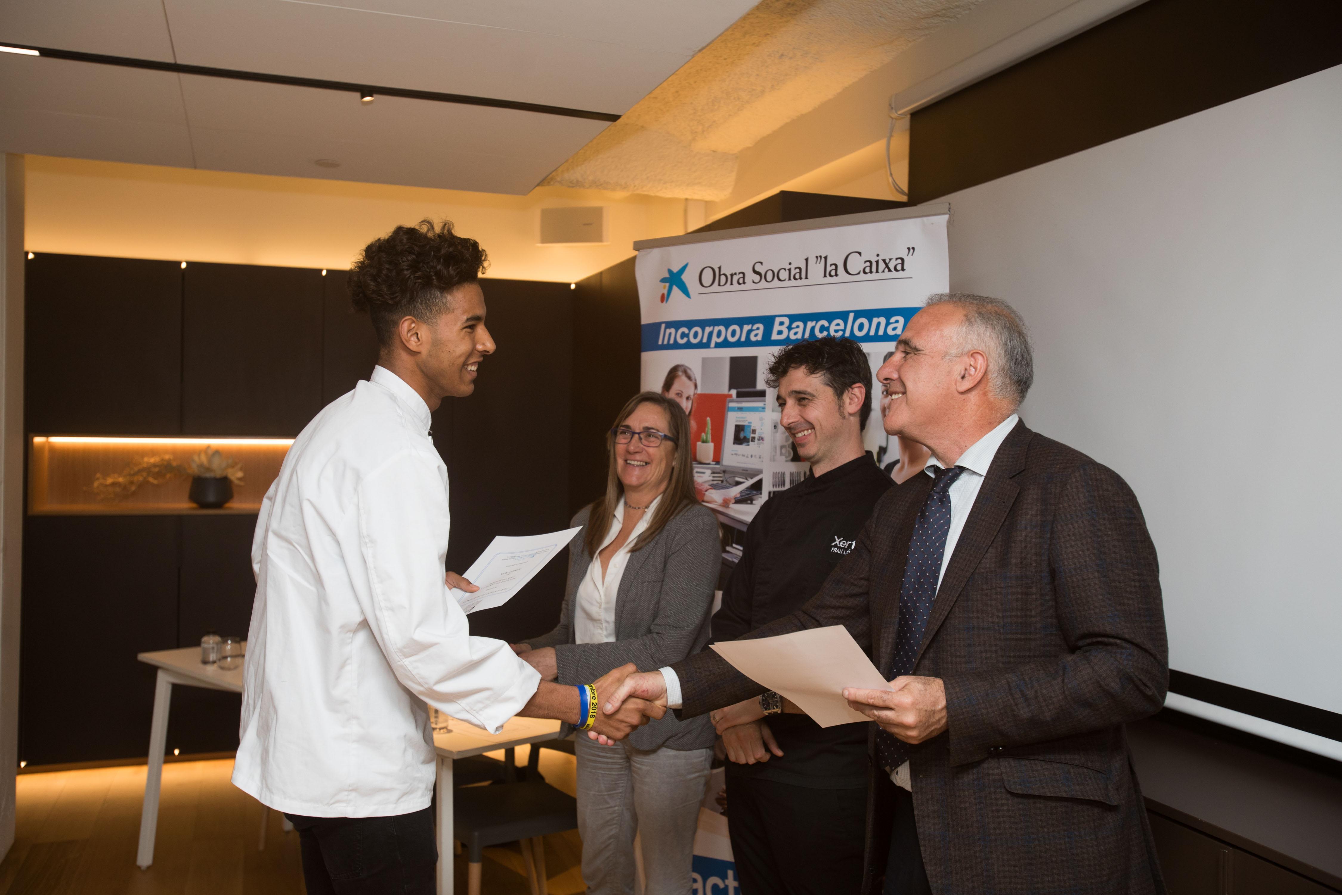 Uno de los alumnos, en el momento de recibir su diploma del Curso de Auxiliar de Cocina