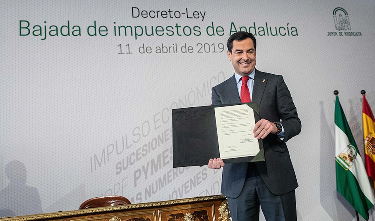 El presidente Juanma Moreno mostrando el decreto de rebajas fiscales aprobado hace unas semanas.
