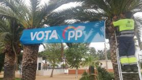 Trabajadores municipales colgando pancartas electorales del PP