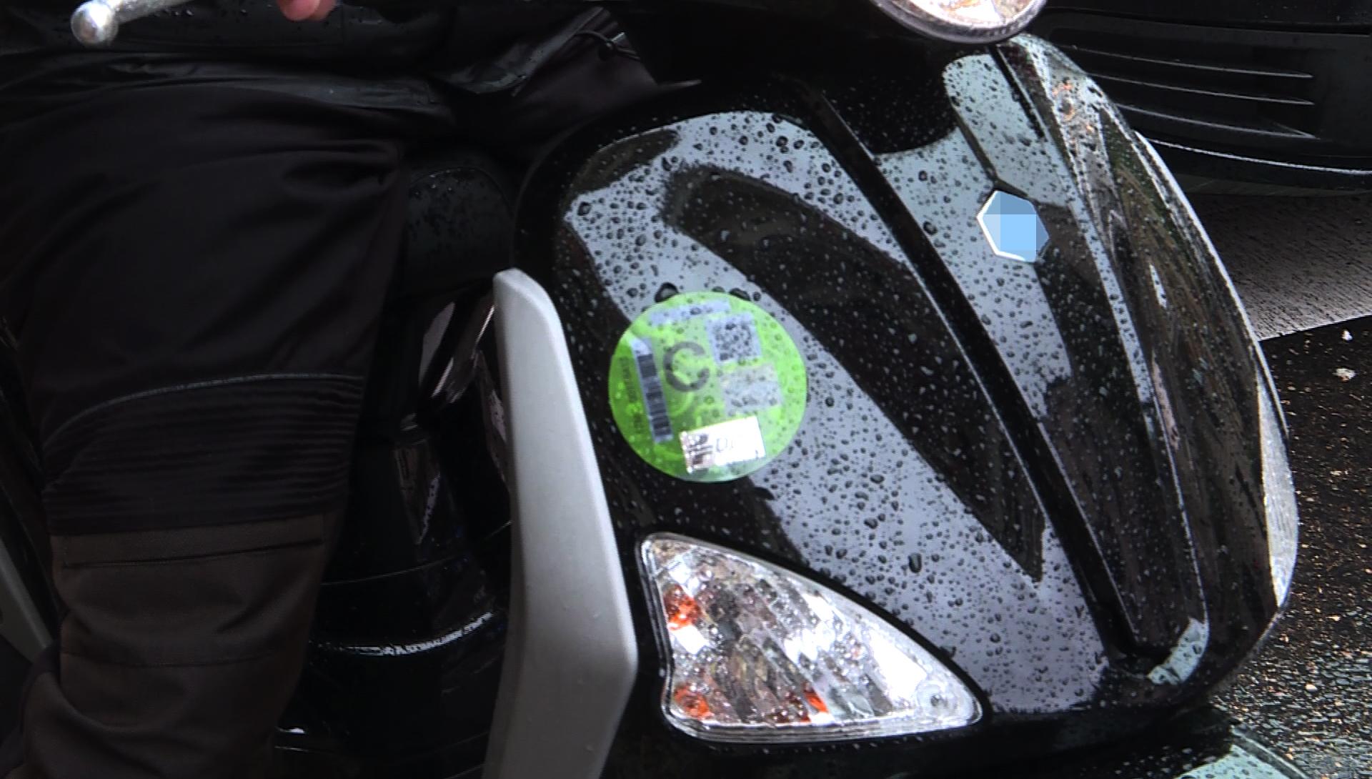 Una moto con un distintivo ambiental de la Dirección General de Tráfico (DGT) de tipo C pegado sobre uno de los faros. Europa Press.
