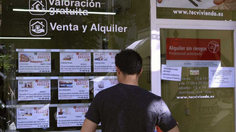 Vista de un escaparate de una inmobiliaria en Madrid, con anuncios de pisos en venta Vista de un escaparate de una inmobiliaria en Madrid, con anuncios de pisos en venta