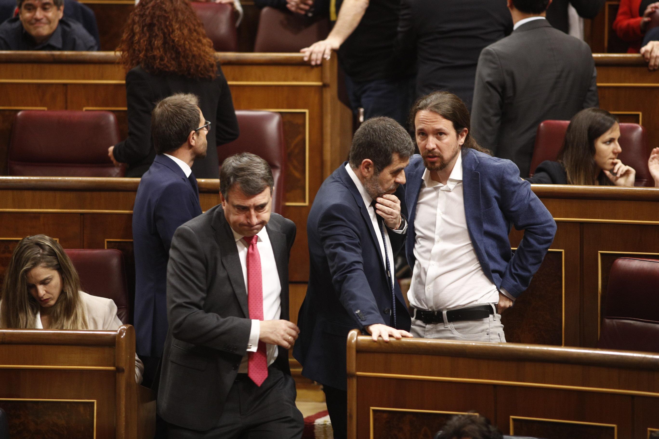 El preso diputado Jordi Sànchez habla con el secretario general de Podemos Pablo Iglesias durante la sesión constitutiva de la Cámara baja 