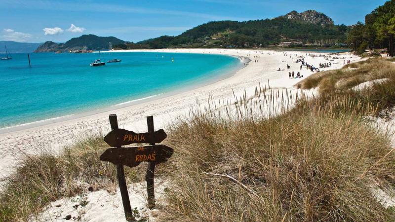 La Playa Rodas Islas Cíes hace una media luna de arena blanca y aguas azules y verdes 