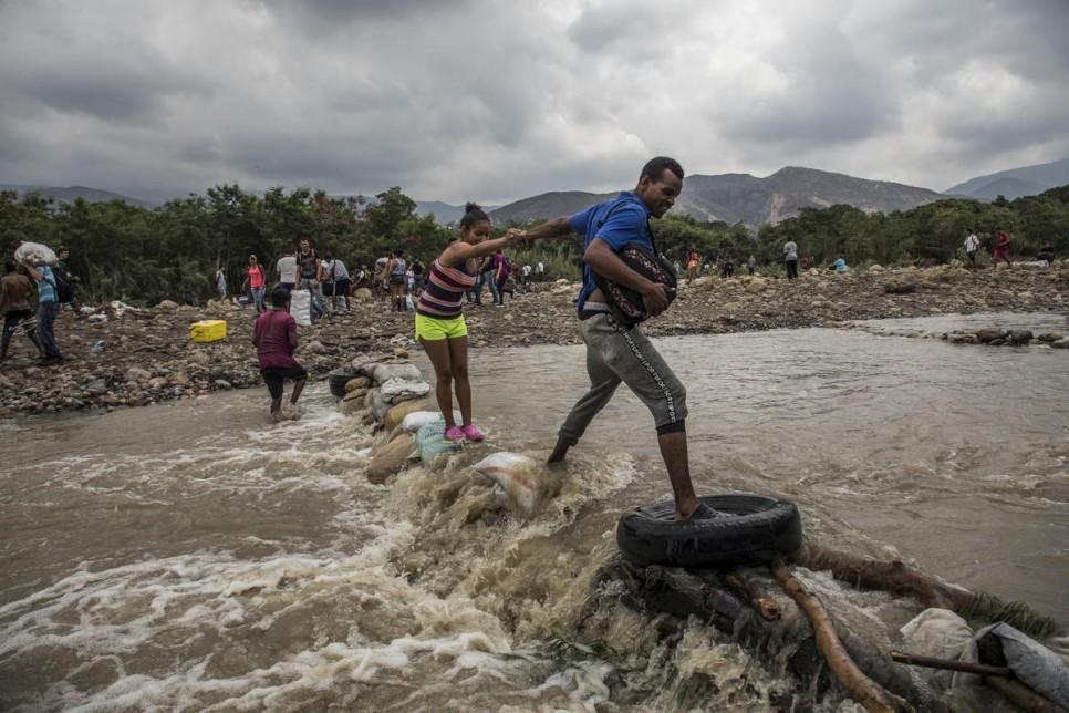 Personas venezolanas cruzan el río Táchira para buscar comida y seguridad en Cúcuta, Colombia