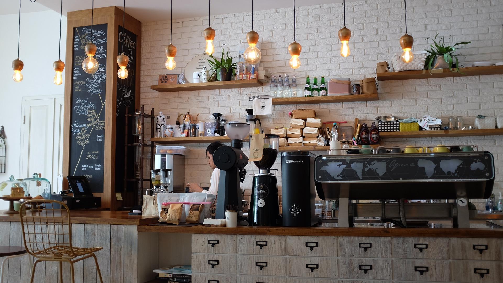 Un trabajador consulta su teléfono móvil en una cafetería