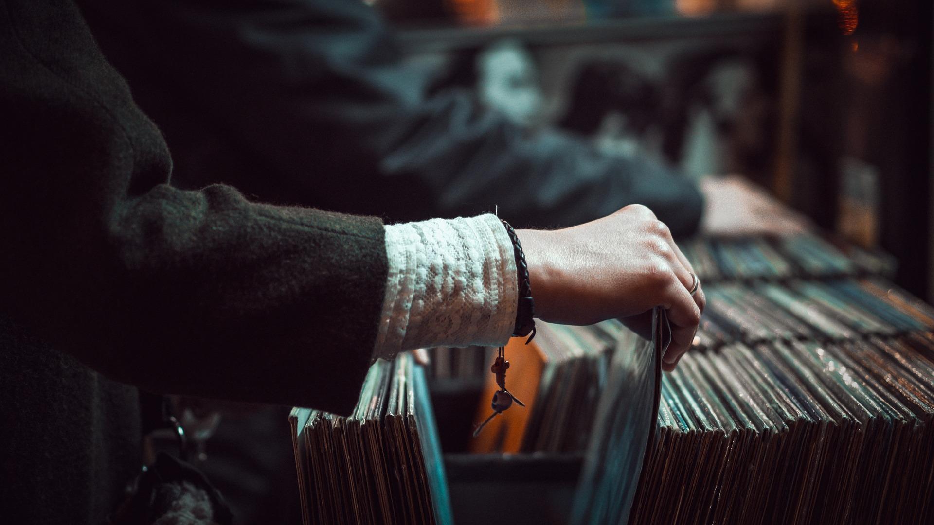 Una mujer buscando vinilos en una tienda de discos