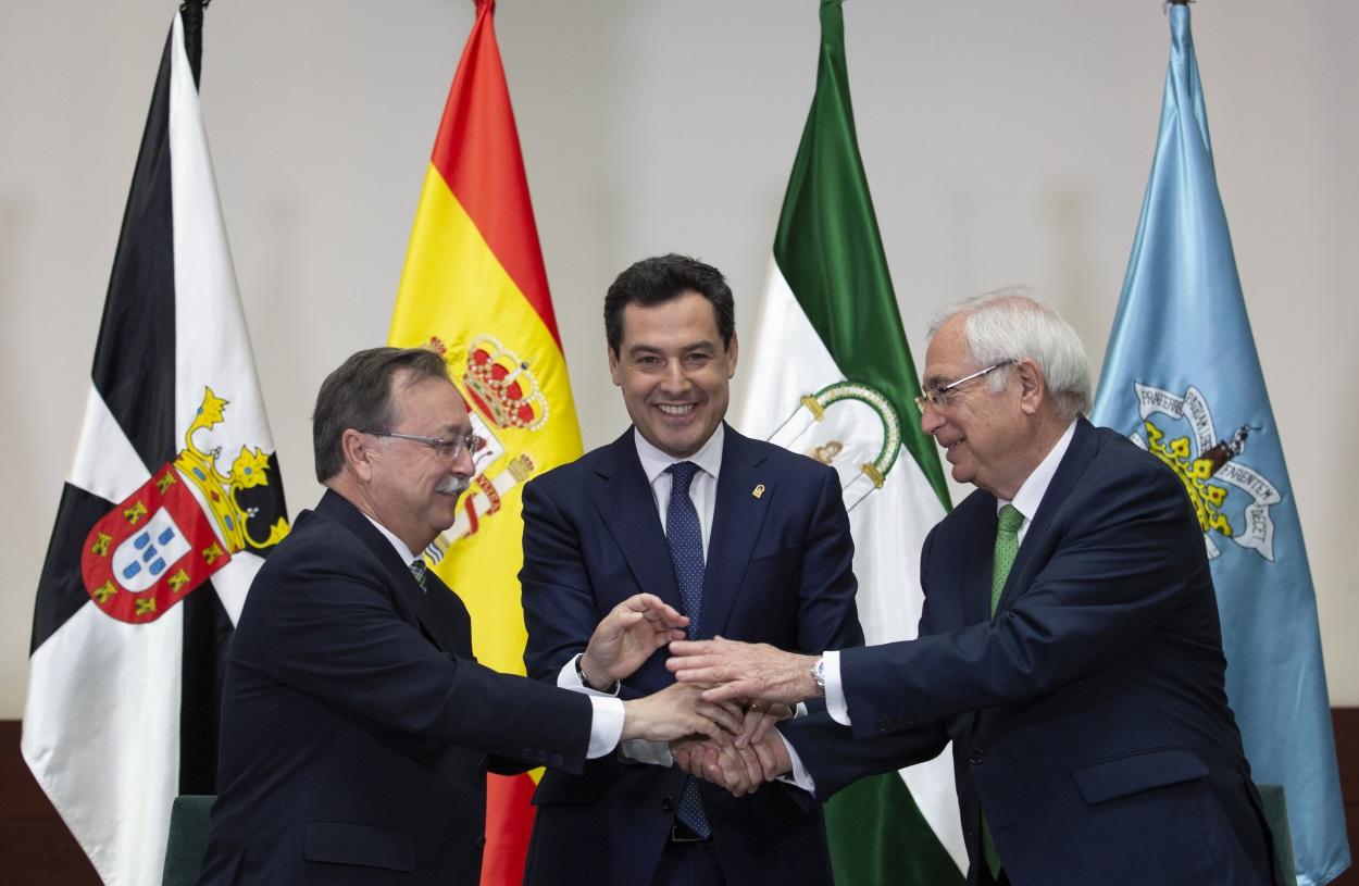 El presidente de la Junta de Andalucía, Juanma Moreno (c), firma un convenio de colaboración con los presidentes de las ciudades autónomas de Ceuta, Juan Jesús Vivas (i), y Melilla, Juan José Imbroda (d).
