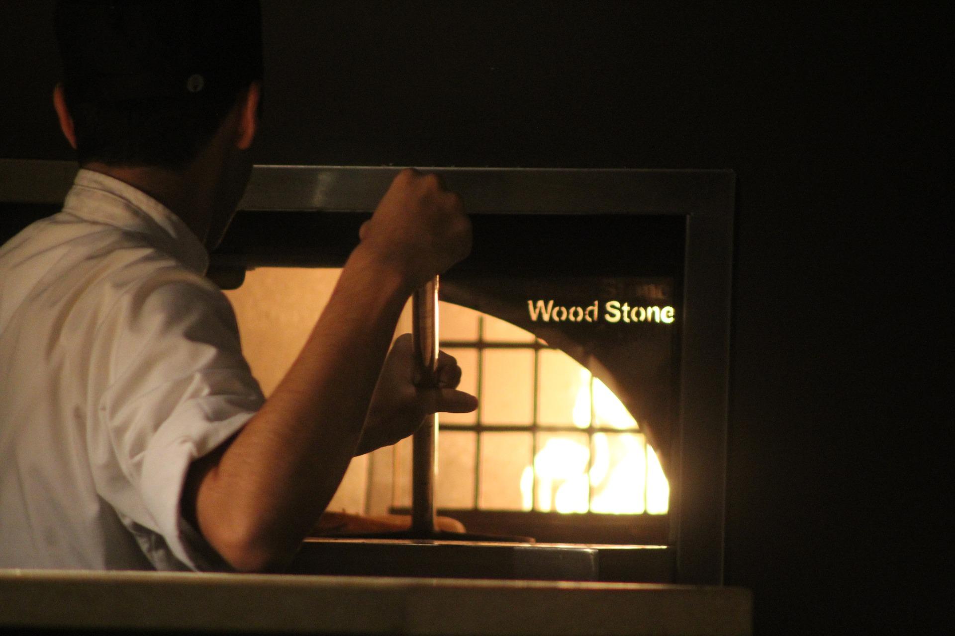 Un pizzaiolo trabaja en un horno de leña. Pixabay