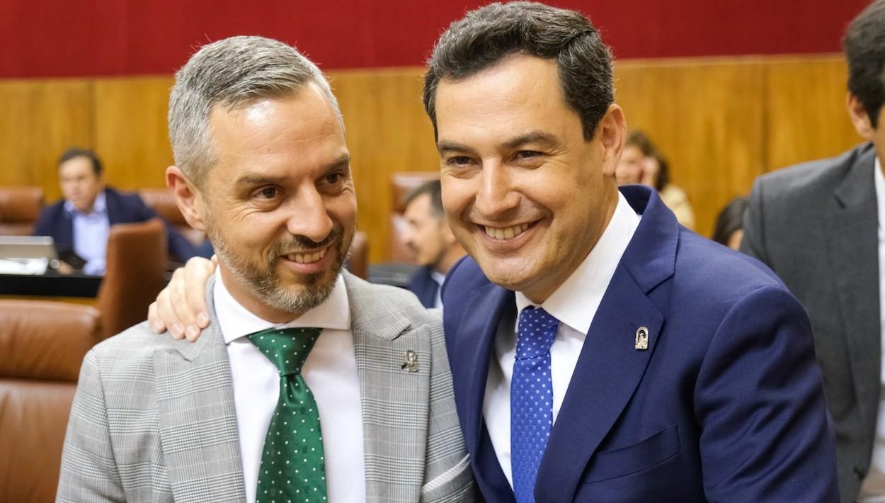 El consejero de Hacienda, Juan Bravo, y el presidente andaluz, Juanma Moreno, sonrientes en el Pleno de hoy.