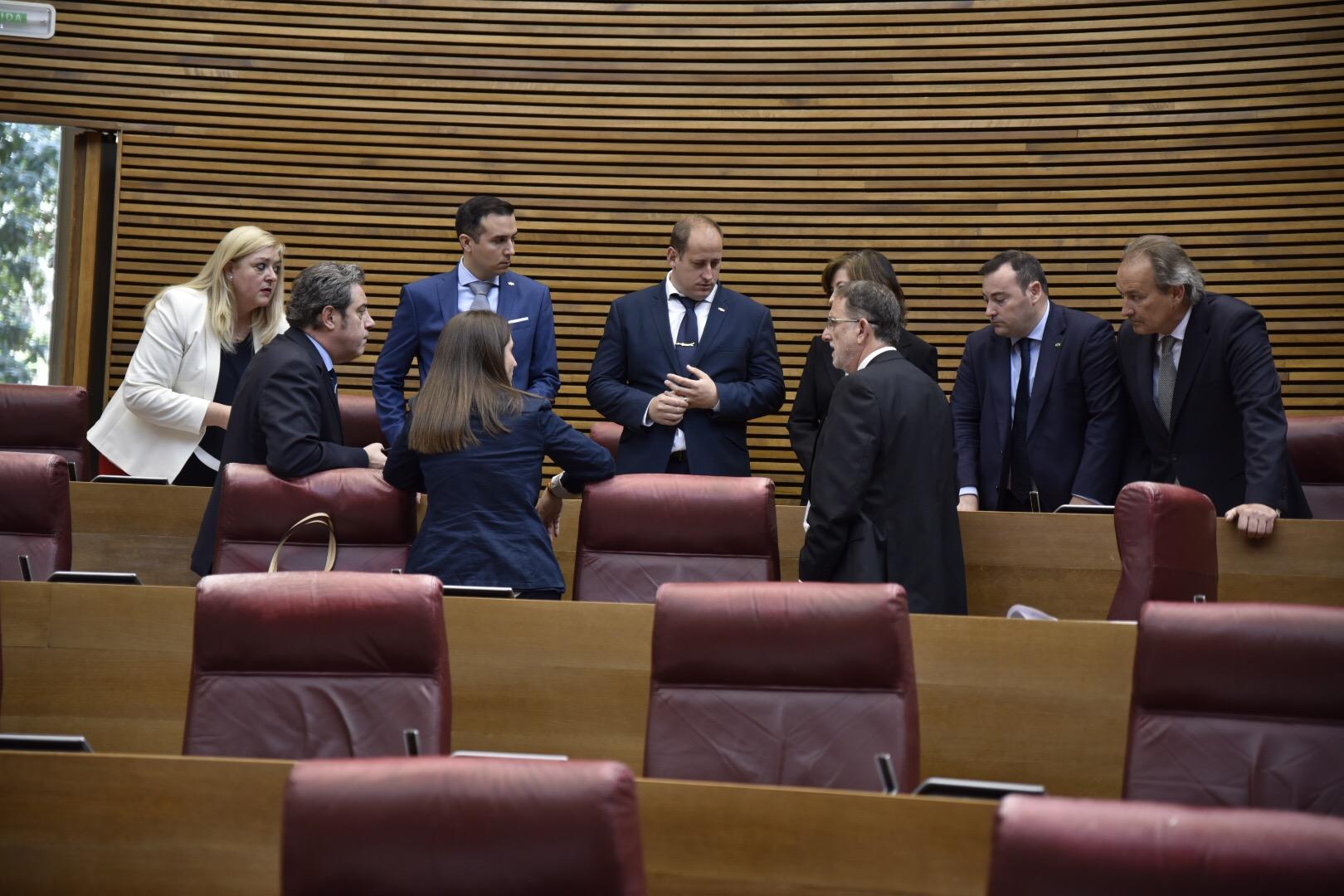 El número tres de Vox en Valencia, Vicente Manuel Roglá (abajo a la derecha), junto al presidente José María Llanos (segundo por la izquierda) y el resto de diputados de su grupo parlamentario (Europa Press)