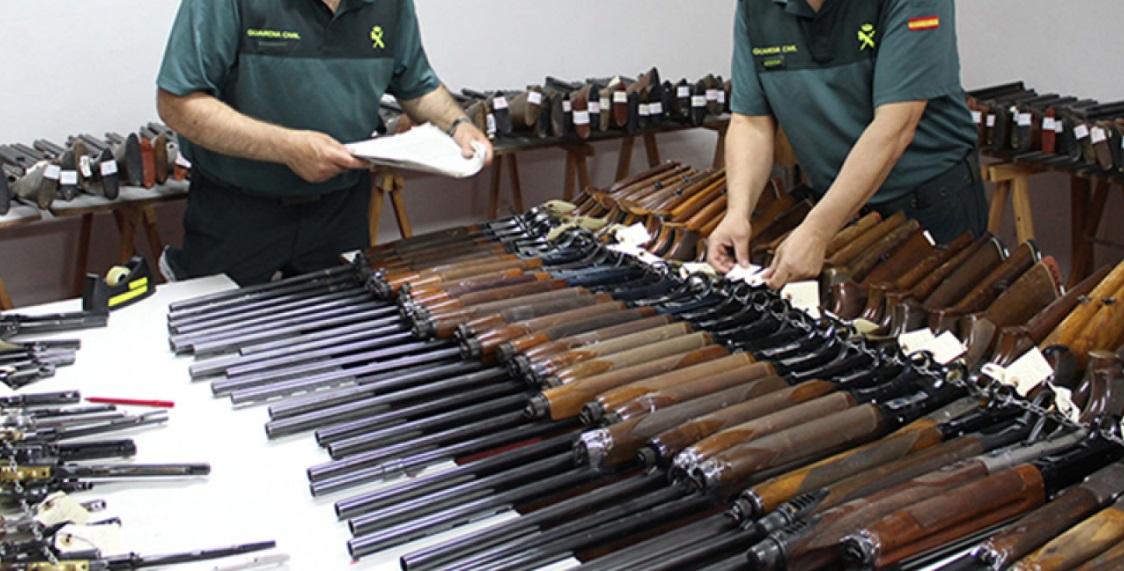 Dos agentes de la Guardia Civil junto a las armas que se subastan. Fuente Guardia Civil
