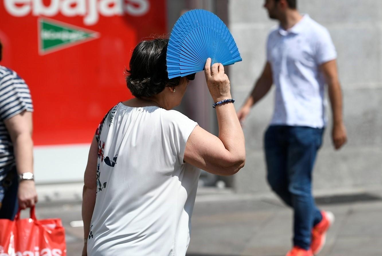 Una mujer con un abanico en la calle. EP